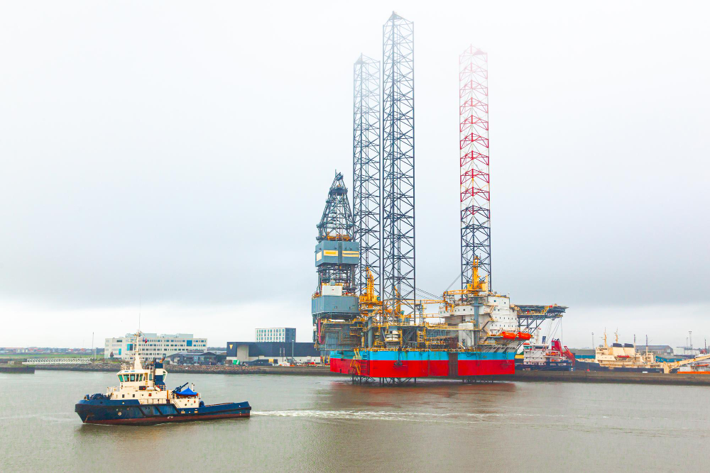 Offshore oil drilling platform stands near the seaport of Gdynia in Poland and a tugboat